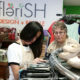 Two friends look at clothing on hangers at the Flerish store.